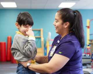 a female nurse helping a young boy