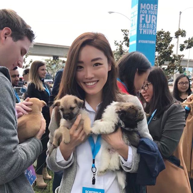 smiling lady holding puppies