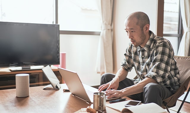Man typing on his laptop while working from home