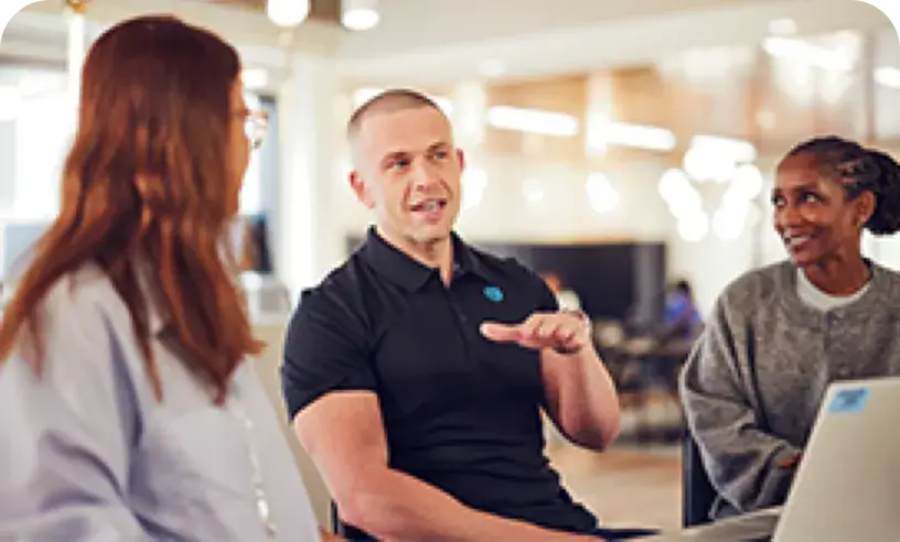 Three people talking in an office setting