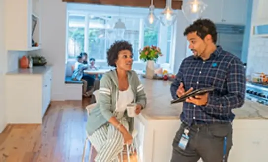 Two people talking in a kitchen area