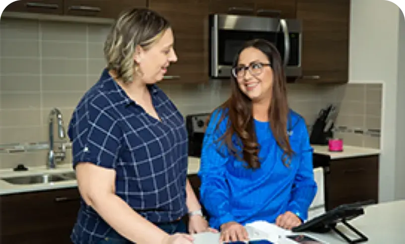Two people talking in a kitchen area