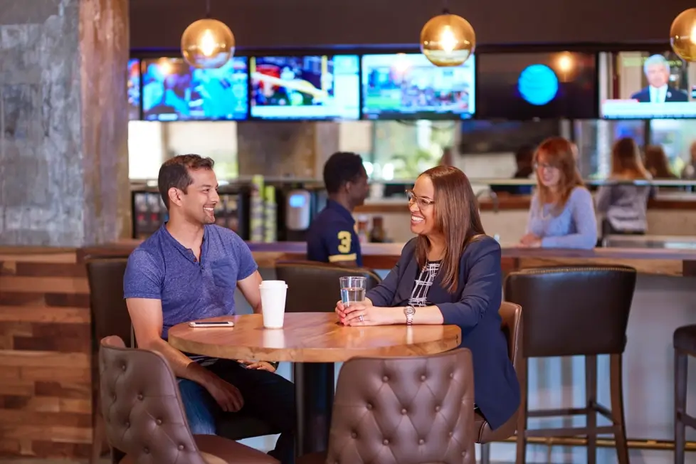 Two people sitting at a table talking to each other