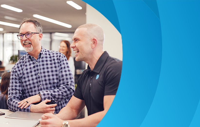 Team members gathered around a desk during an office discussion