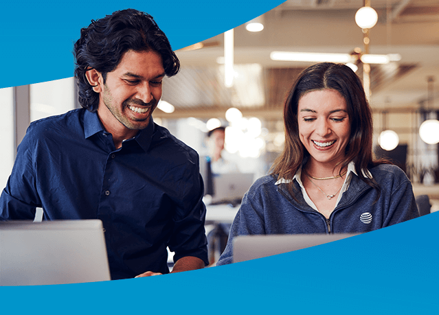 Man and woman smiling while working at computers together