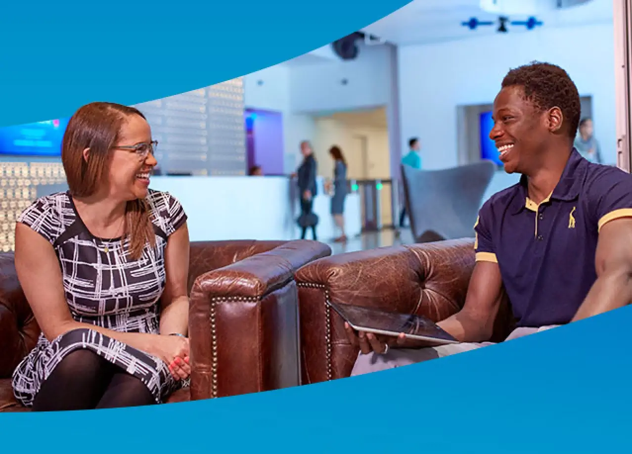 Man and woman sitting on couches smiling at each other.