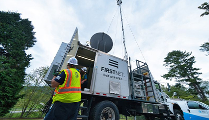 FirstNet® truck with antennae on top with worker with yellow AT&T vest