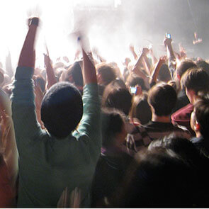 Crowd of people cheering at a concert