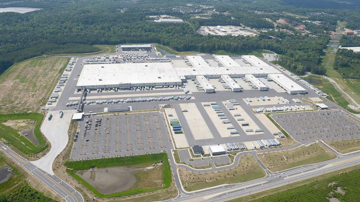 Aerial view of large warehouse building and surrounding rural area