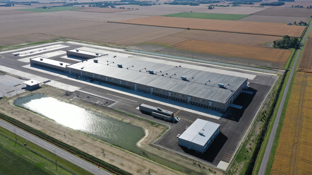 Aerial view of large warehouse building and fields