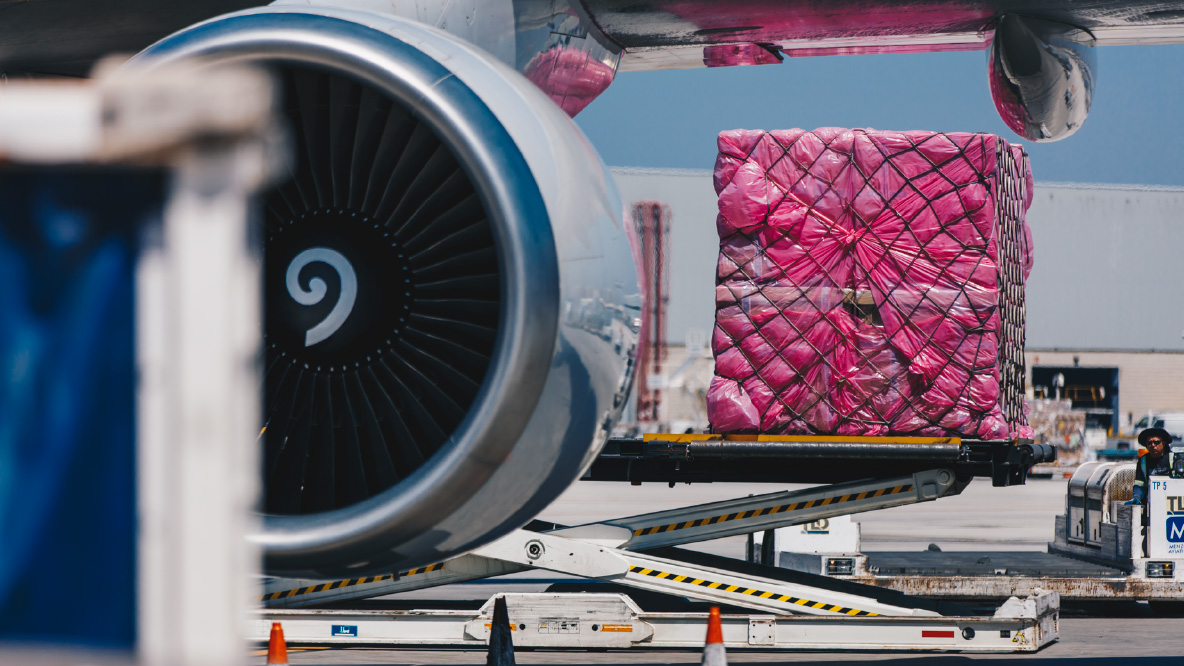 A large shipment package being loaded onto a plane