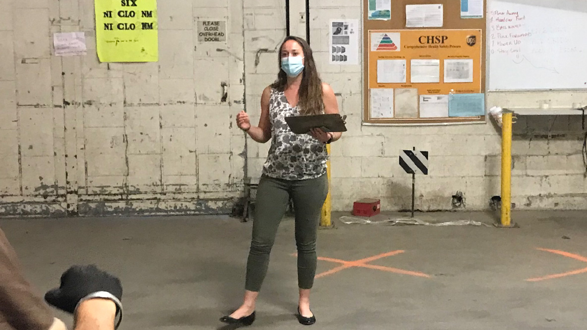 Woman wearing a mask and holing a clipboard.