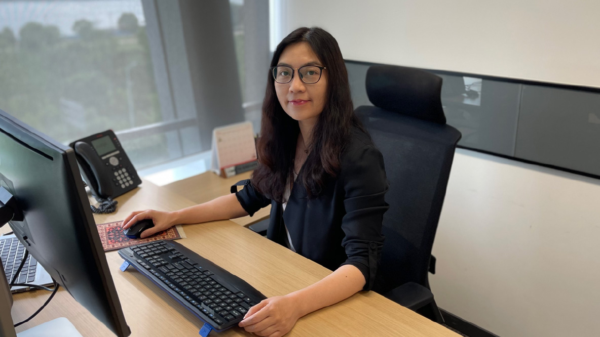 A woman sitting at a desk, smiling