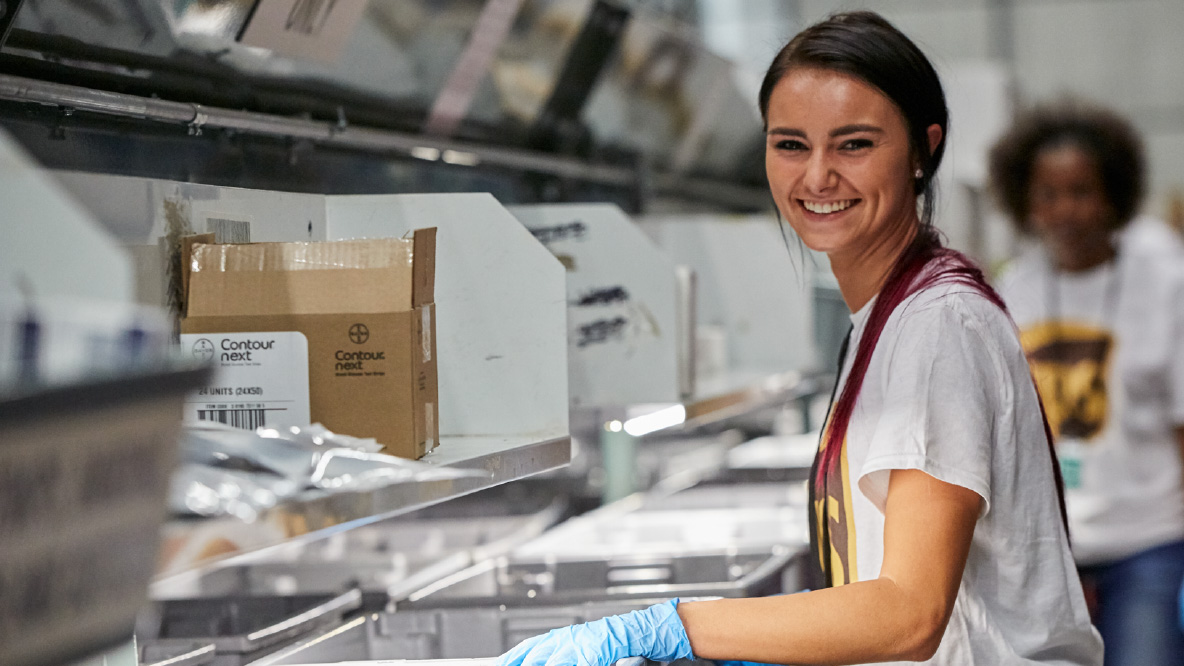 A UPS healthcare warehouse worker working on the conveyer belt