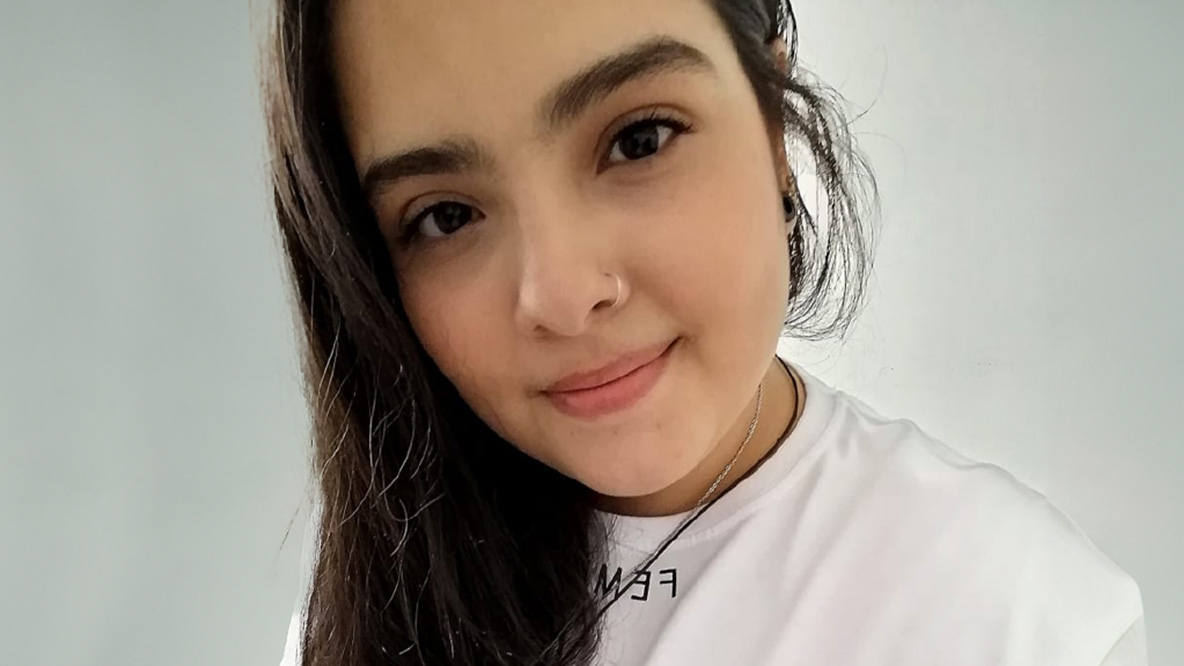 Woman smiling wearing a white shirt.