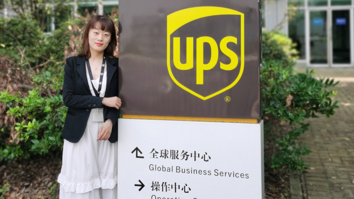 A woman standing next to a UPS sign