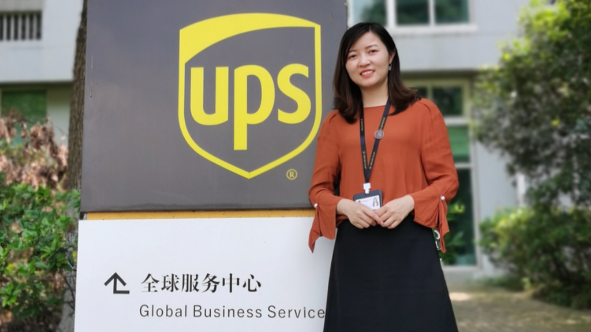 A woman standing next to a UPS sign