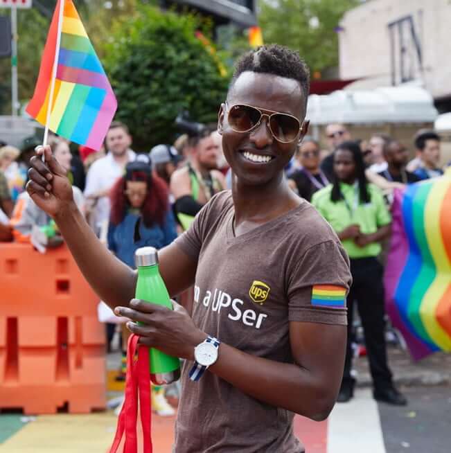 African-American man holding a LGBTQ flag