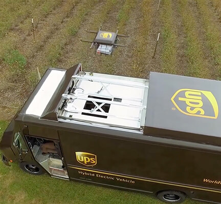 UPS truck sits in field with drone above it