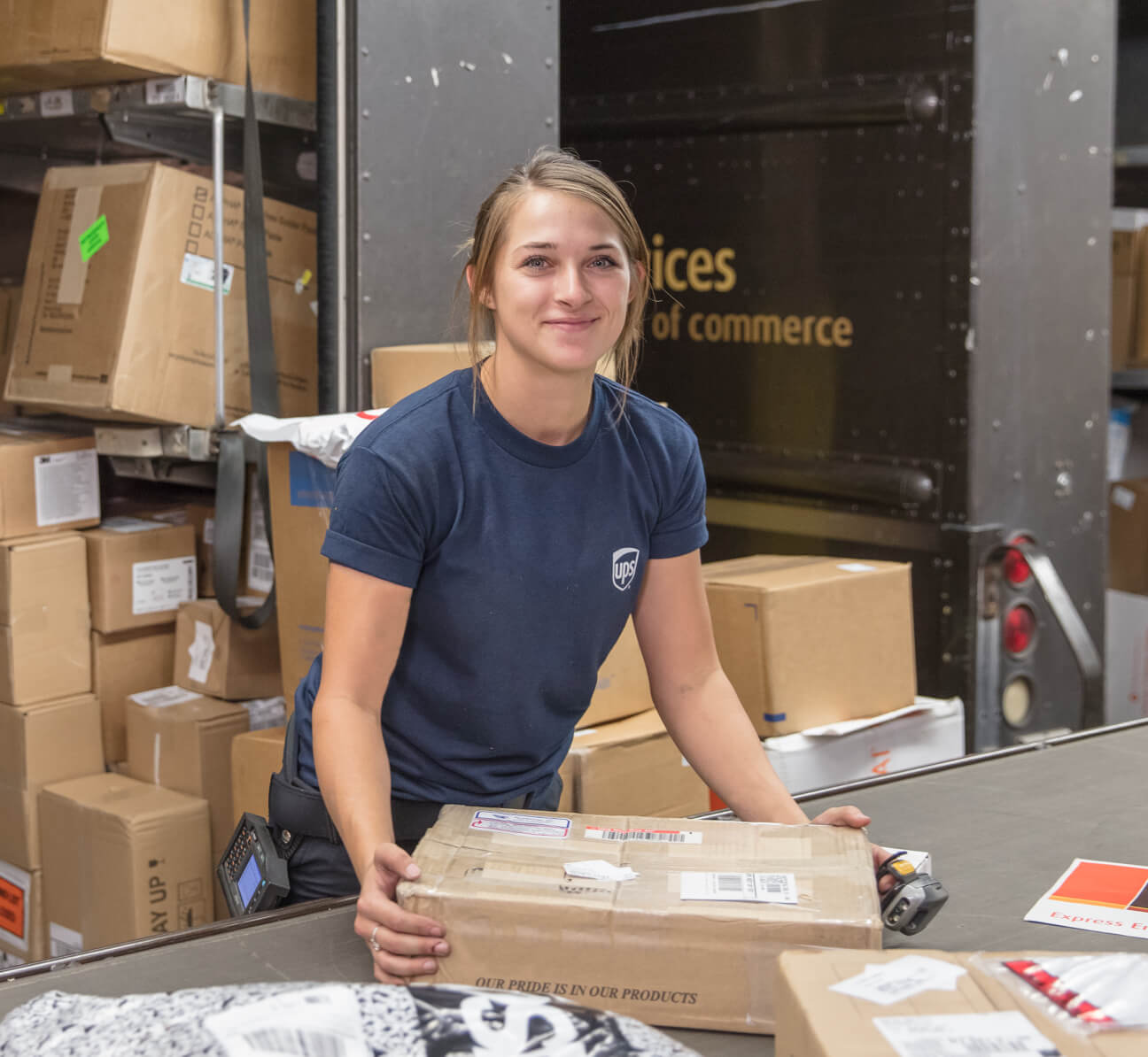Female employee smiling while sorting packages