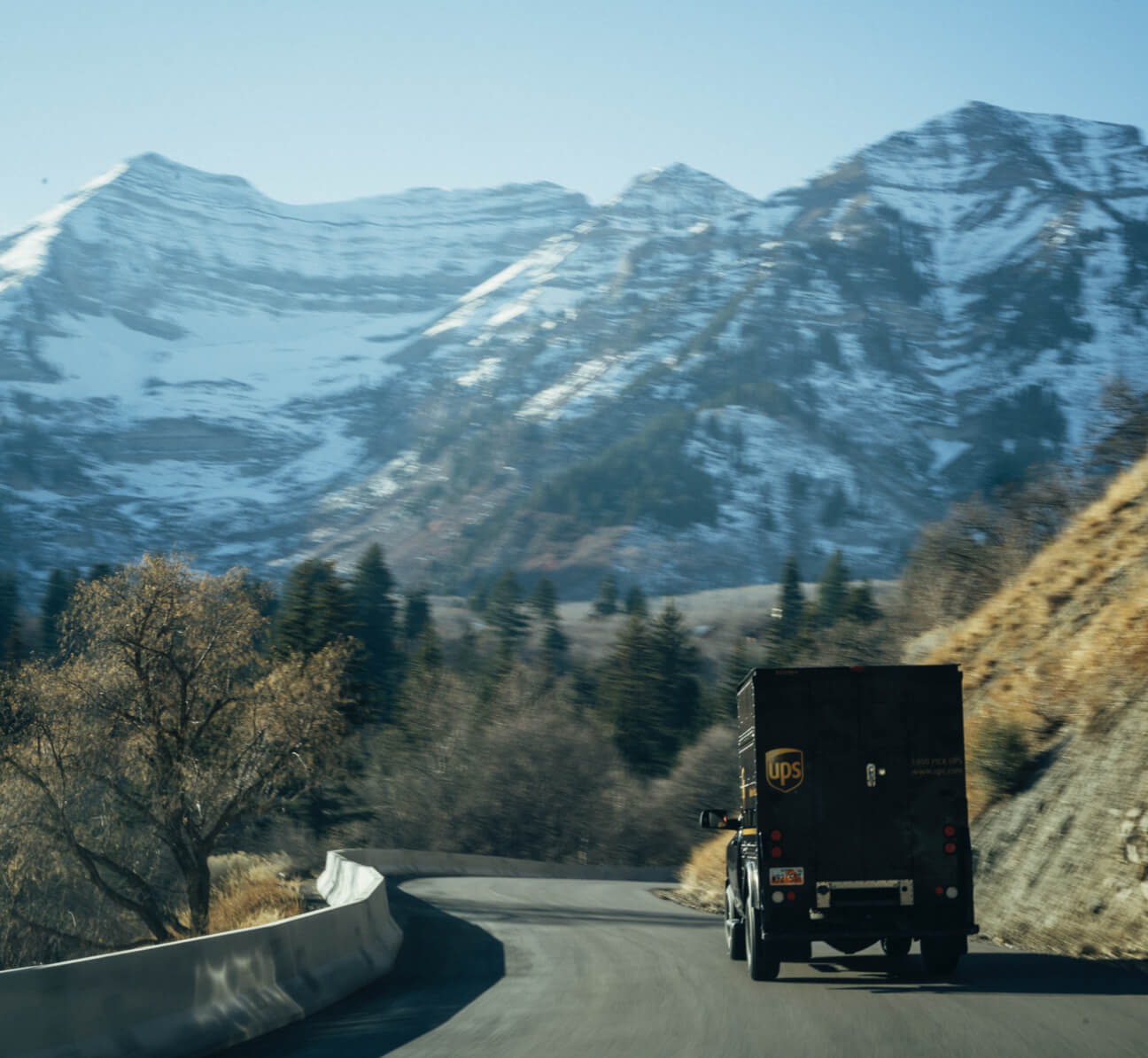 UPS Delivery Truck driving on road with mountains in background