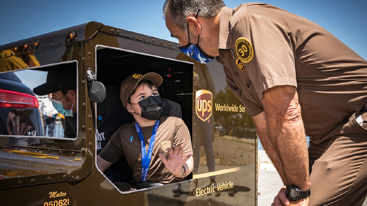 A UPS Driver talking to a child from the Make a Wish foundation