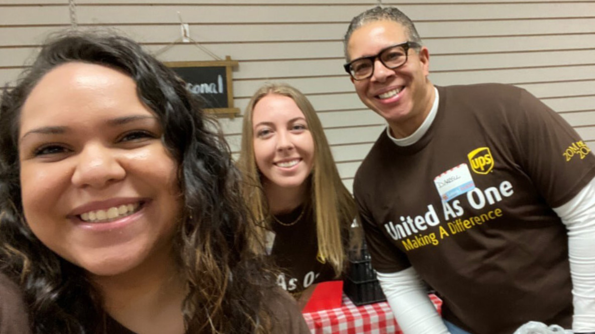 A group of three UPS workers smiling for a selfie