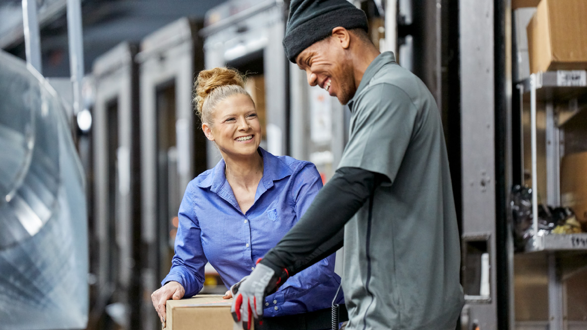 Two UPS Package Handlers in a warehouse