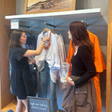 a woman looking at clothes in a clothing store