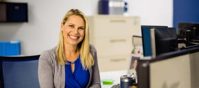 USAA employee writing at a desk