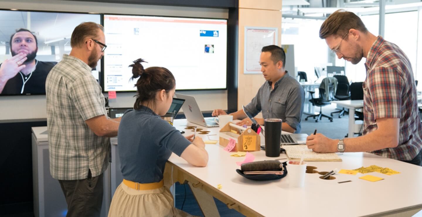 Employees standing at a communal office desk