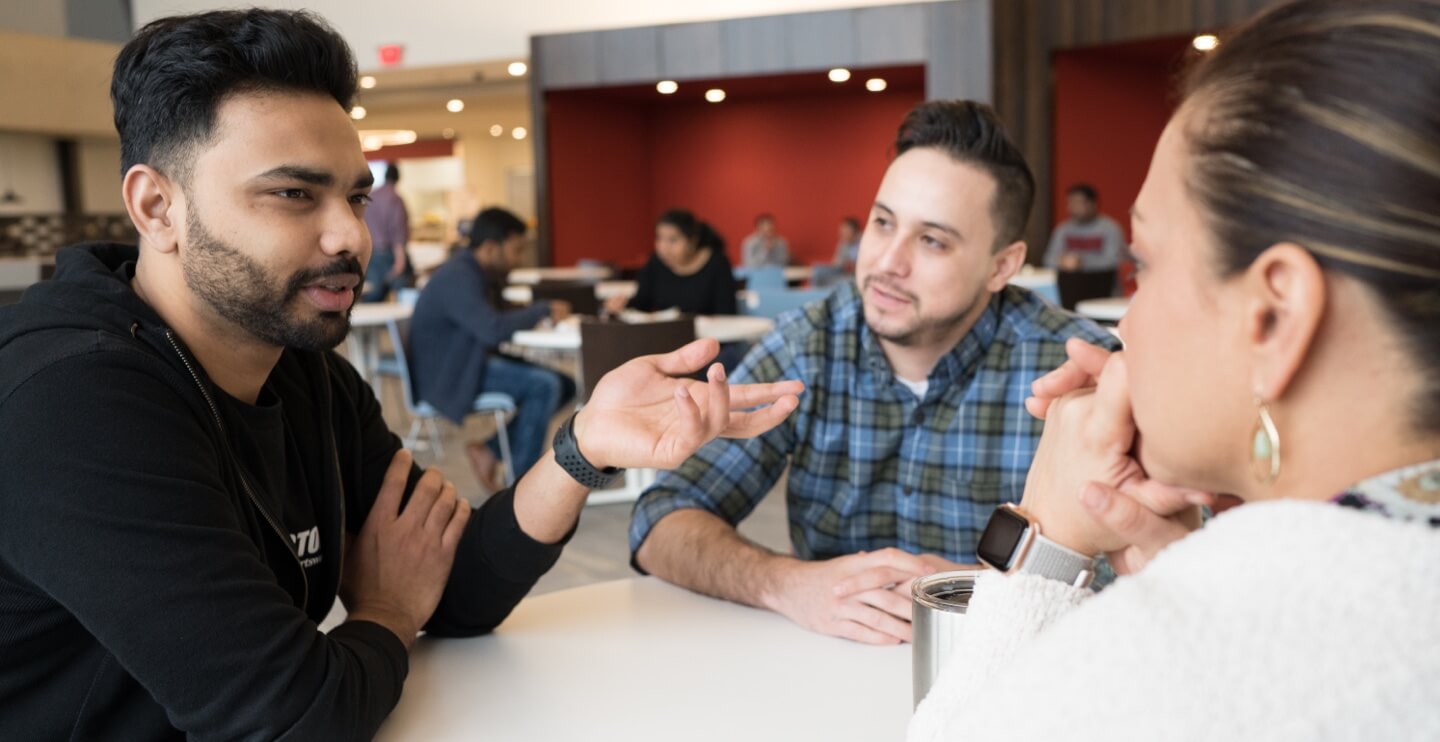 Three people talking at a table