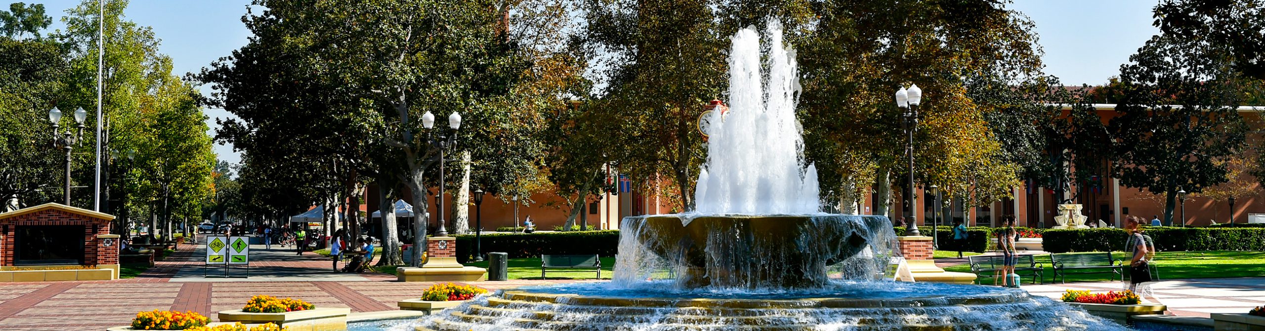 View of USC's University Park Campus featuring a central fountain, tree-lined walkways, and outdoor gathering spaces.