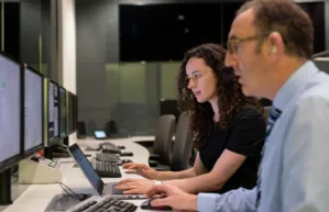 People working at computers with multiple monitors