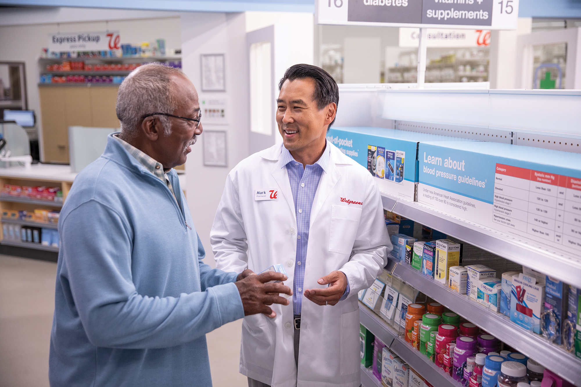 Pharmacist in a white coat helping a customer in the aisle