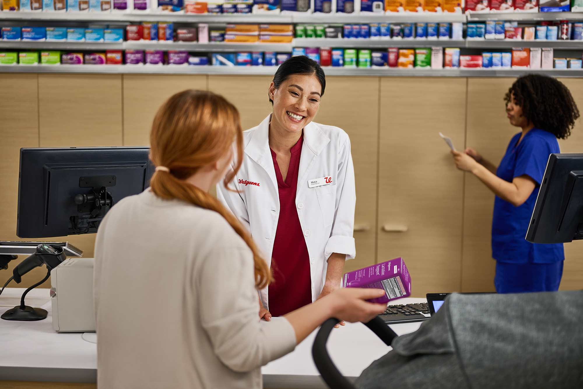 Female pharmacists standing at counter helping a customer