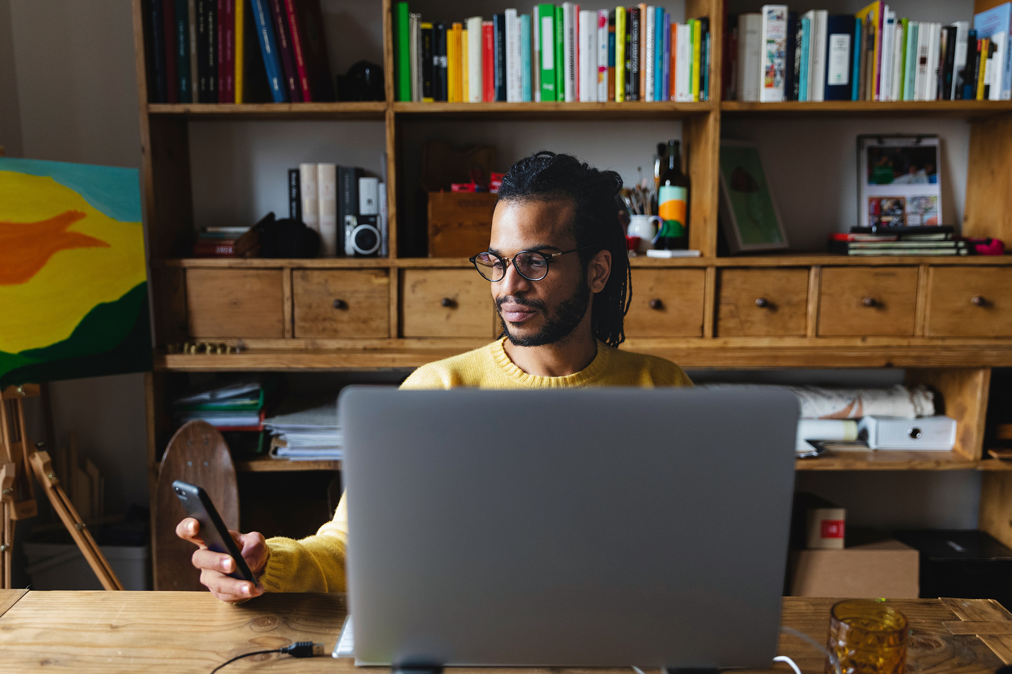 Man with cell phone and laptop in an office