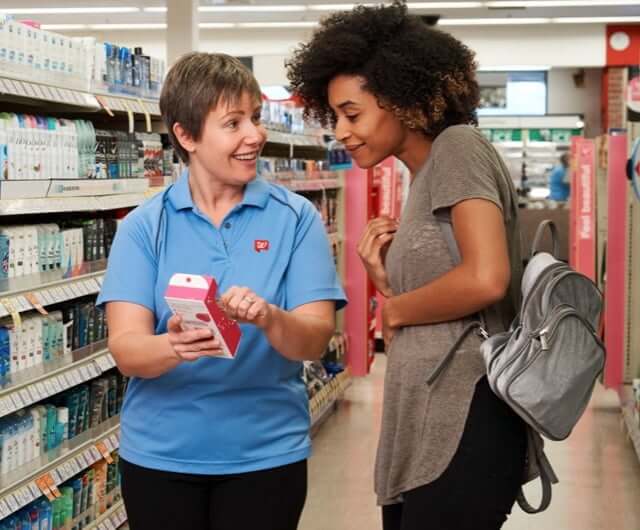 Walgreens employee helping a customer find medicine