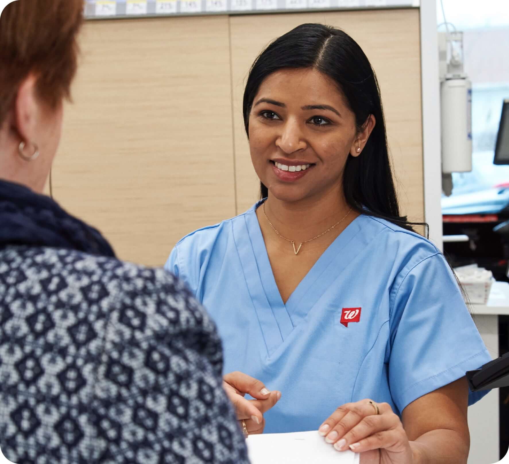 Nurse handing medication to customer