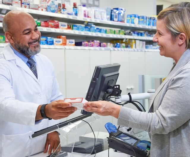 Pharmacist handing customer prescription