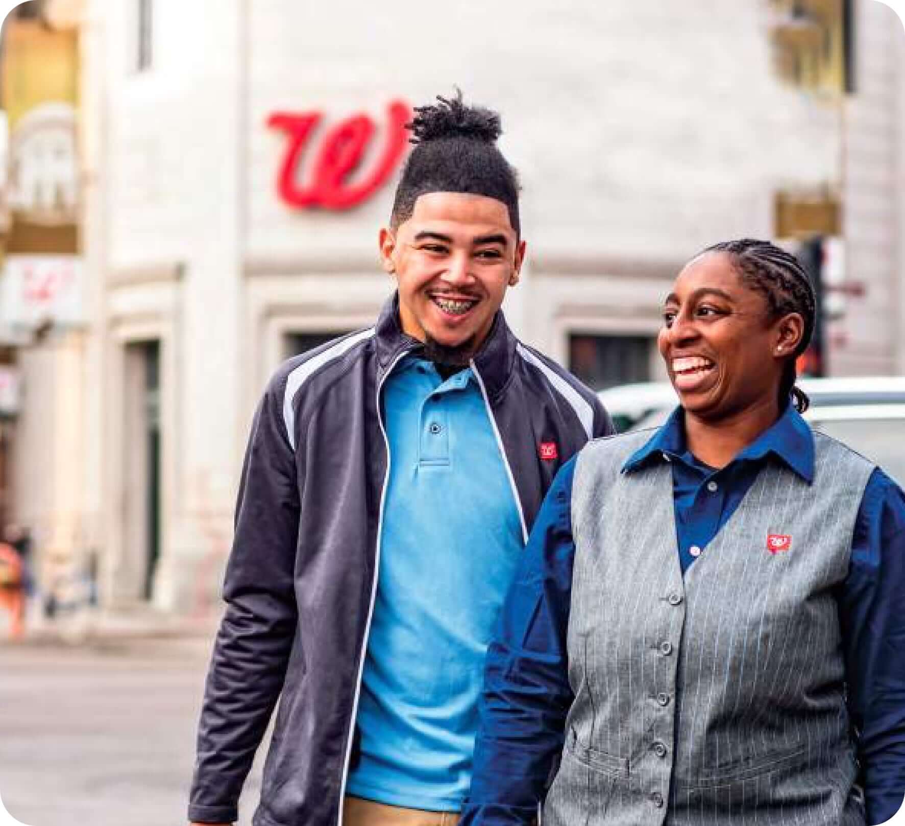Two Walgreens employee laughing in front of the store