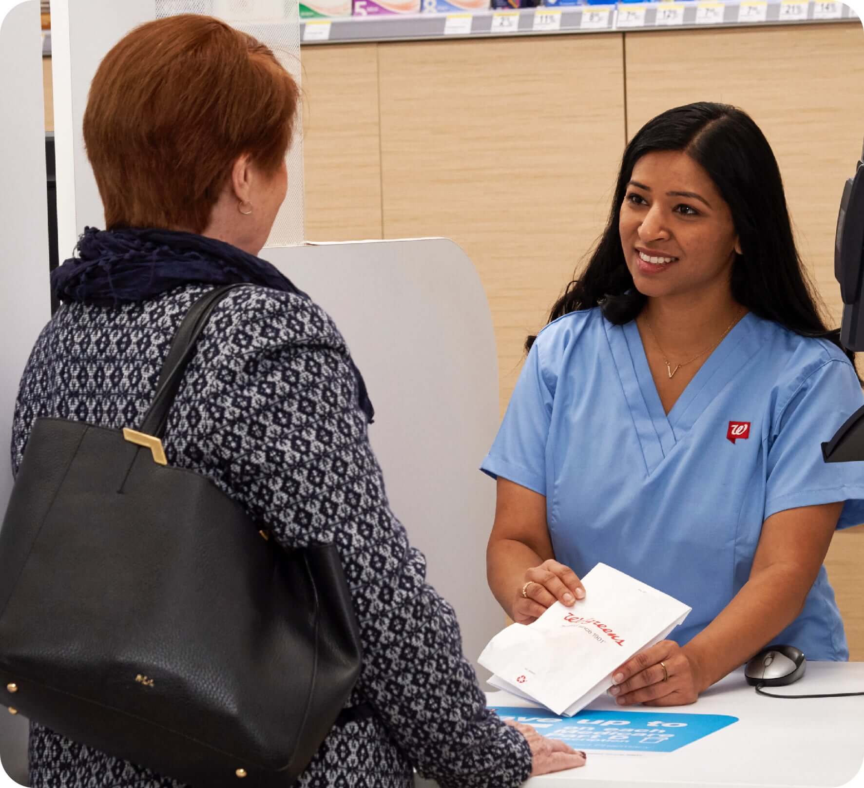 Walgreens pharmacist handing over medication