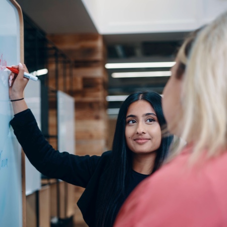 Neha writing on a whiteboard