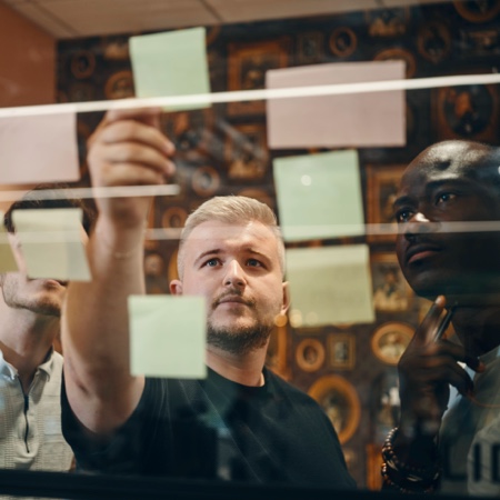 Mat pointing to post it note on glass wall