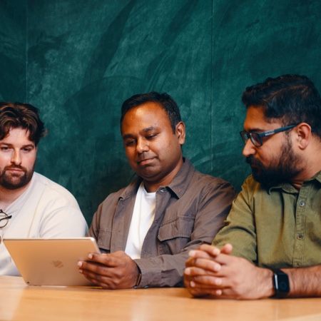 Akshat on laptop with colleagues