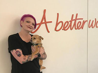 Related Content: Person with short pink hair holding a dog