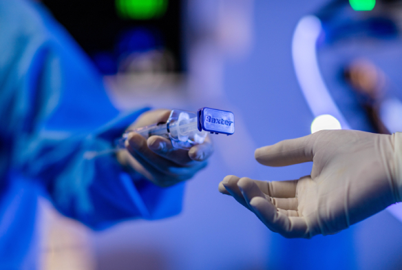 Gloved surgeon handing item