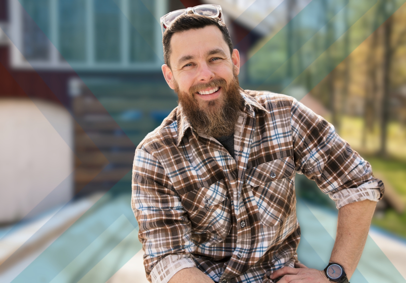 Man in plaid shirt with arm on hip sitting down