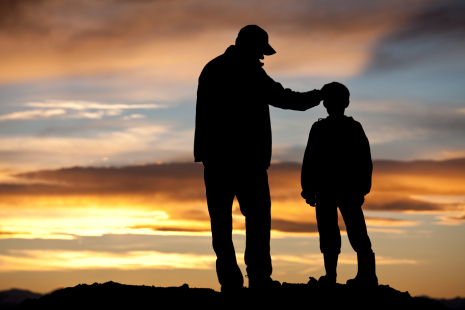 Silhouette of man and son, looking into sunset