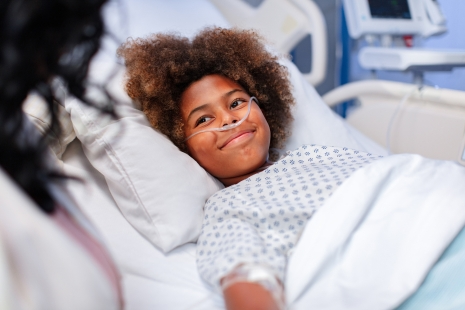 Smiling kid on a hospital bed